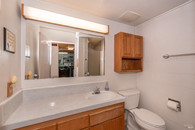 full bath with a shower with shower door, vanity, and toilet