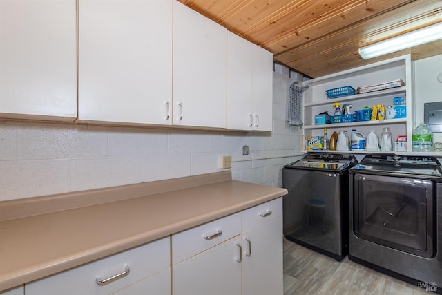 laundry area with light wood-type flooring, wooden ceiling, cabinet space, and washer and dryer