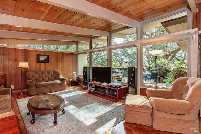 living area with vaulted ceiling with beams, wood walls, wood ceiling, and wood finished floors