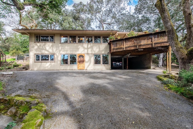 view of front facade with driveway and a wooden deck