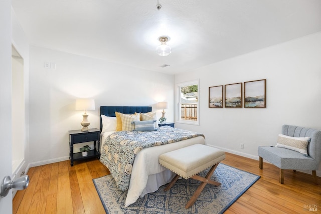 bedroom featuring baseboards, visible vents, and light wood-style floors