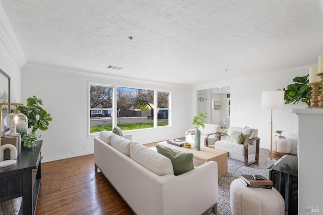 living room featuring crown molding, visible vents, hardwood / wood-style floors, a textured ceiling, and baseboards