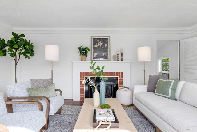 living room featuring a fireplace, crown molding, and wood finished floors