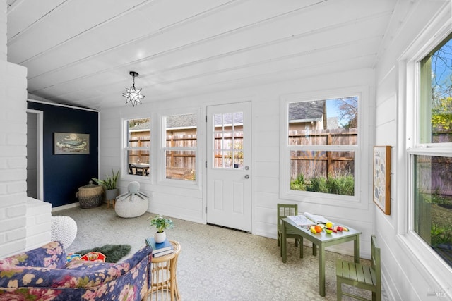 sunroom / solarium featuring a notable chandelier