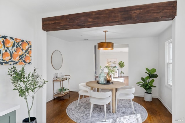 dining space with baseboards and wood finished floors