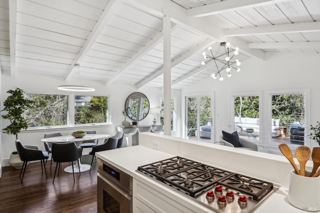 kitchen featuring dark wood-style flooring, stainless steel appliances, light countertops, lofted ceiling with beams, and a chandelier