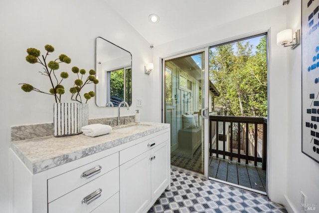 bathroom featuring lofted ceiling, tile patterned floors, vanity, and recessed lighting