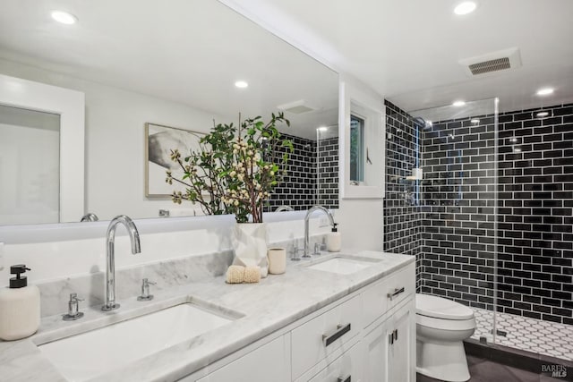 bathroom featuring a stall shower, visible vents, a sink, and toilet