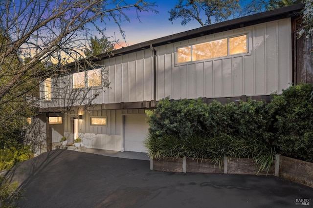 view of front of property with board and batten siding, driveway, and an attached garage