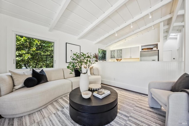 living area featuring plenty of natural light, wooden ceiling, vaulted ceiling with beams, and wood finished floors