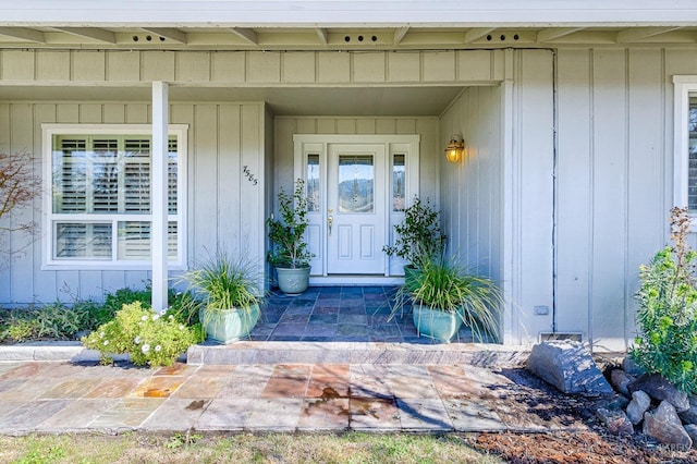 property entrance with covered porch and board and batten siding