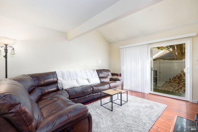 living area featuring lofted ceiling with beams and hardwood / wood-style flooring