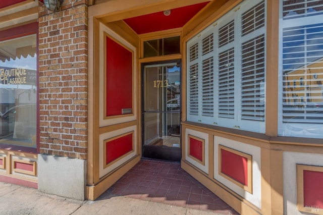 entrance to property featuring brick siding