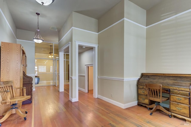 home office with wood-type flooring, visible vents, ceiling fan, and baseboards