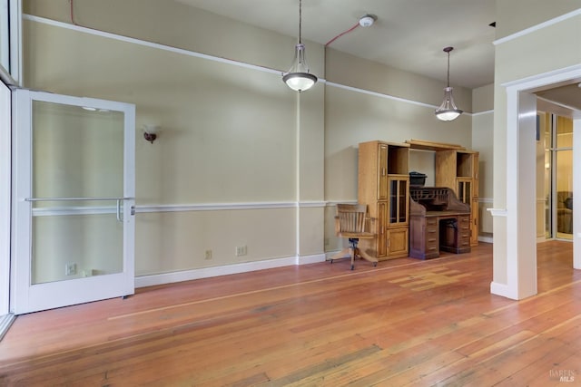 unfurnished dining area with baseboards and hardwood / wood-style floors