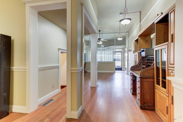 interior space featuring light wood finished floors, baseboards, and visible vents