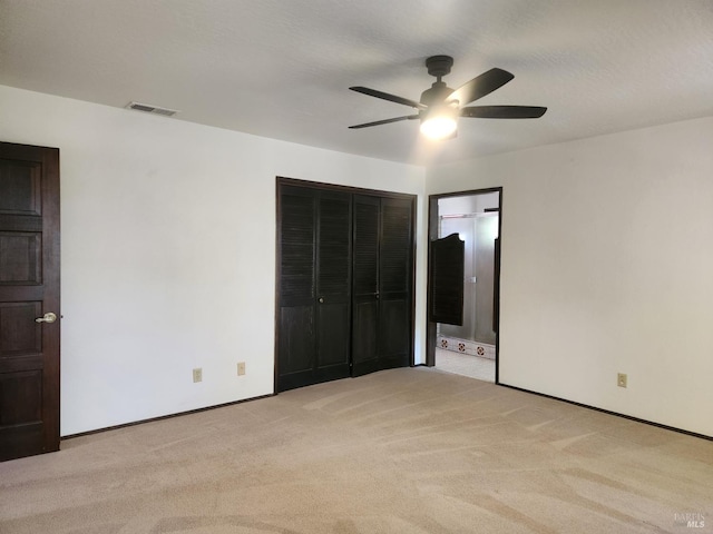 unfurnished bedroom featuring a closet, light colored carpet, visible vents, ceiling fan, and baseboards