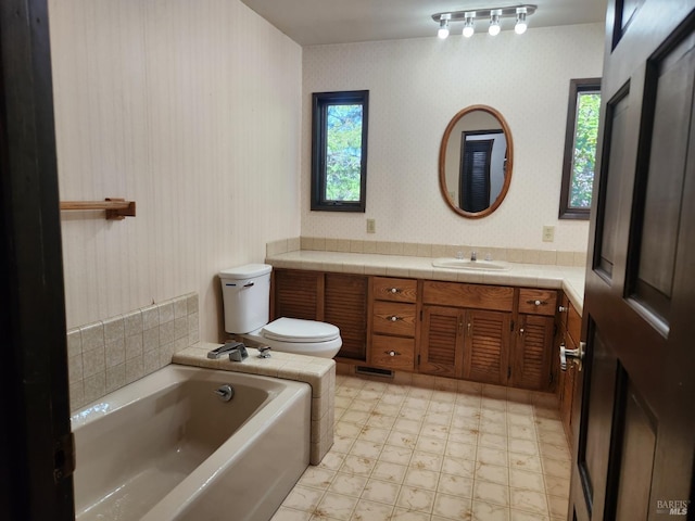 bathroom with a garden tub, tile patterned floors, vanity, and wallpapered walls