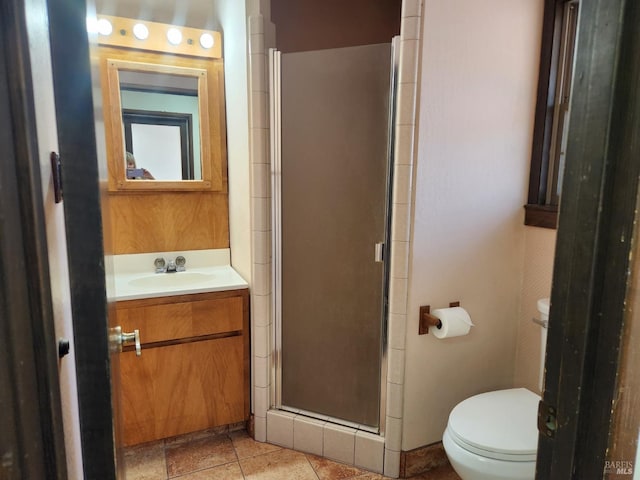 bathroom featuring toilet, vanity, a stall shower, and tile patterned flooring