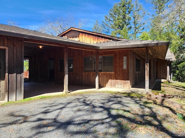 exterior space with board and batten siding, crawl space, and roof with shingles