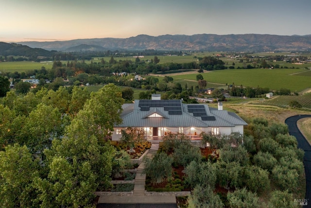 aerial view at dusk featuring a rural view and a mountain view