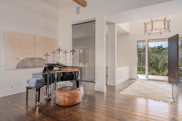 entrance foyer featuring baseboards, a towering ceiling, and wood-type flooring