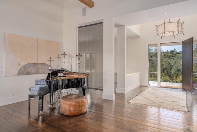 foyer entrance with hardwood / wood-style flooring, a high ceiling, and baseboards