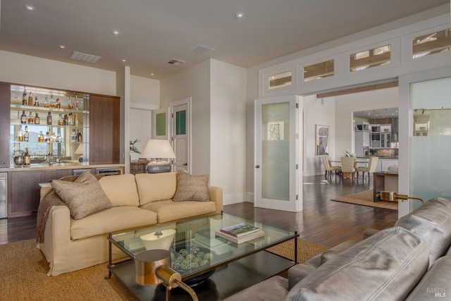 living area with wood finished floors, visible vents, recessed lighting, and wet bar