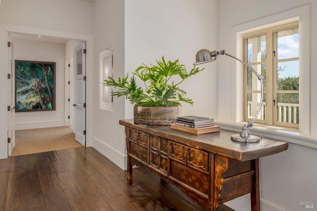 corridor featuring baseboards and hardwood / wood-style floors