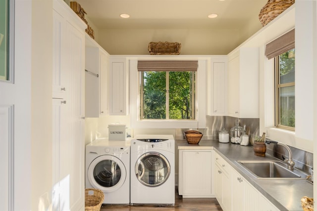 laundry area featuring washing machine and dryer, recessed lighting, cabinet space, and a sink