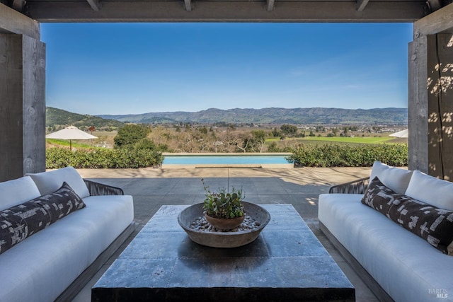 view of patio / terrace with an outdoor pool, a mountain view, and outdoor lounge area