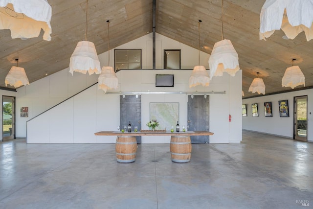 unfurnished living room featuring concrete flooring and high vaulted ceiling