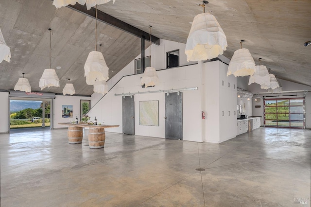 unfurnished living room featuring plenty of natural light, finished concrete flooring, and high vaulted ceiling