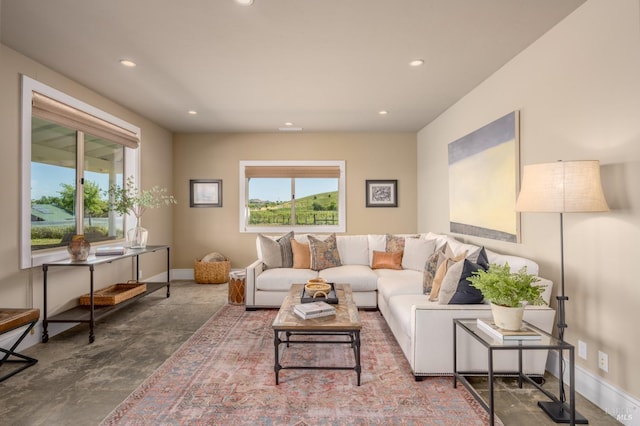 living room featuring recessed lighting, concrete flooring, and baseboards