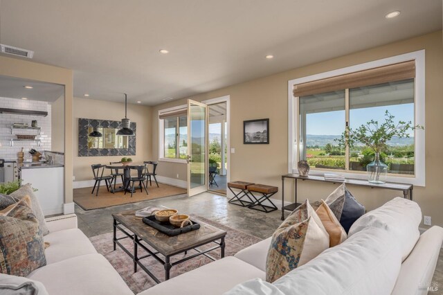 living area with recessed lighting, visible vents, and baseboards