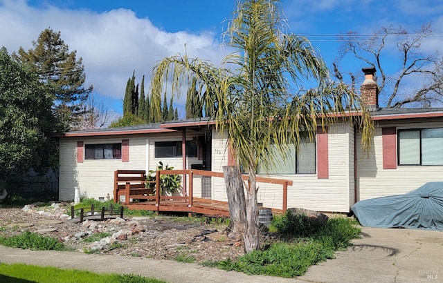 view of front of property featuring a chimney and a wooden deck