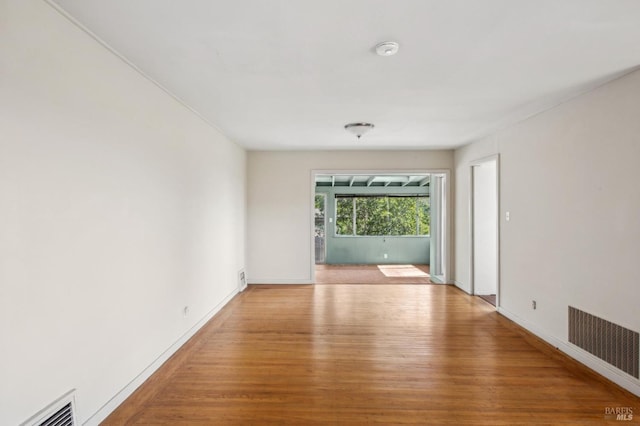 empty room featuring visible vents, baseboards, and light wood-style floors