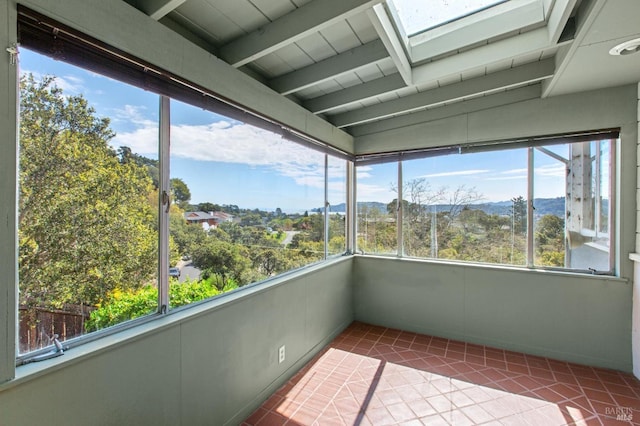 unfurnished sunroom with lofted ceiling with skylight