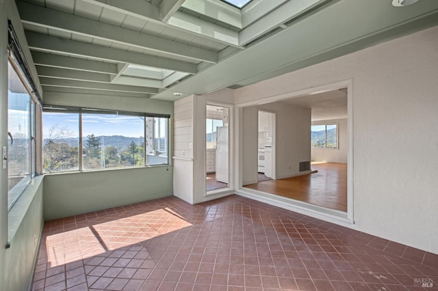 unfurnished sunroom with a wealth of natural light and beam ceiling