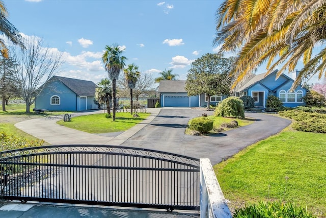 exterior space featuring a garage, driveway, a front yard, and fence