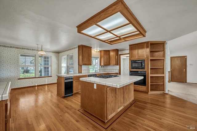 kitchen featuring open shelves, tile counters, a kitchen island, black appliances, and wallpapered walls