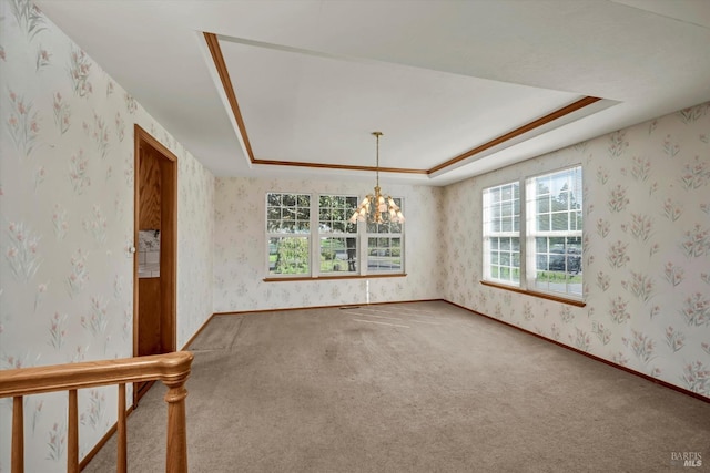 unfurnished room featuring baseboards, an inviting chandelier, a raised ceiling, and wallpapered walls