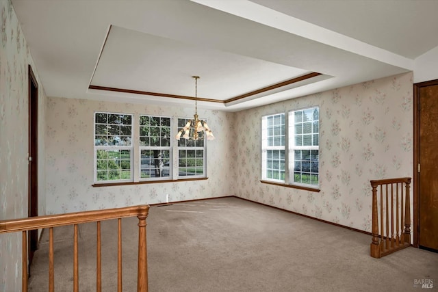 unfurnished room featuring a chandelier, a wealth of natural light, a raised ceiling, and wallpapered walls