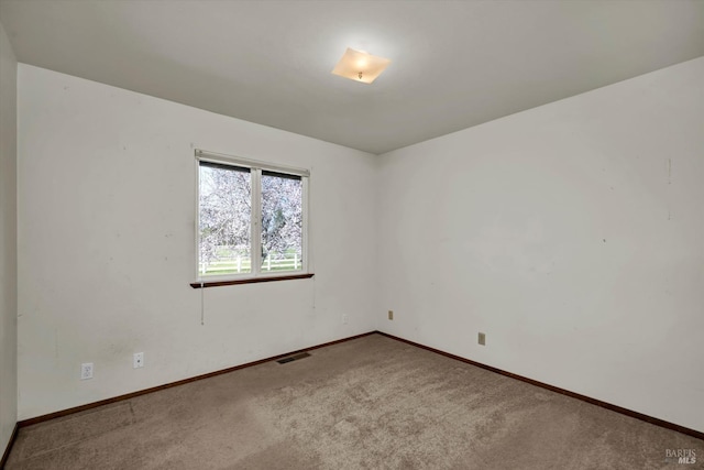 carpeted empty room with visible vents and baseboards