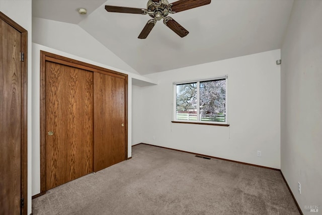 unfurnished bedroom with visible vents, baseboards, ceiling fan, vaulted ceiling, and carpet floors