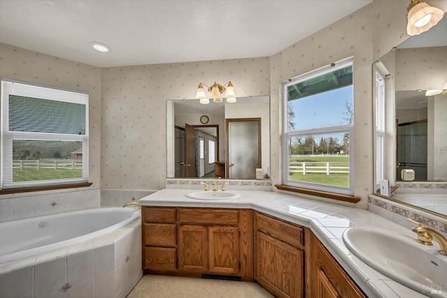 full bath featuring double vanity, a sink, a bath, and wallpapered walls