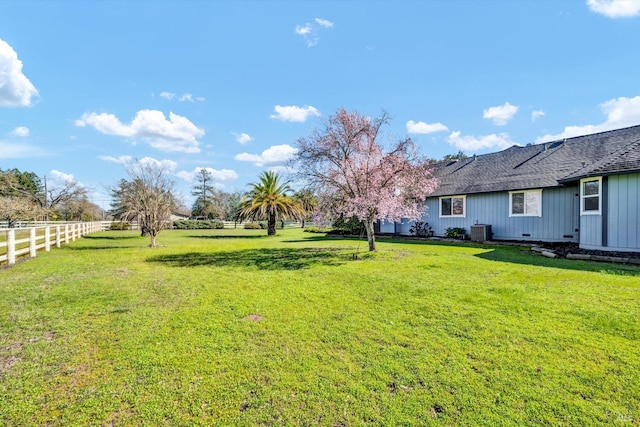 view of yard with fence and central AC unit