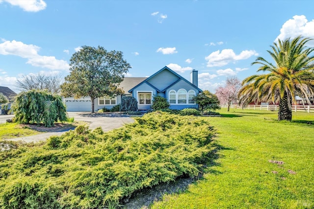 view of front of house with a garage, a front yard, fence, and a chimney