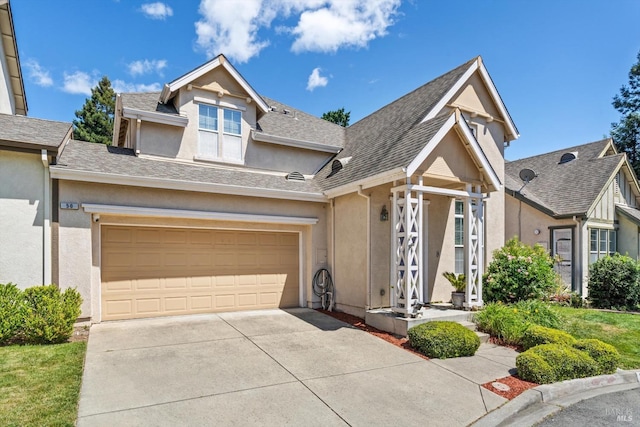 view of front facade featuring a garage, driveway, roof with shingles, and stucco siding