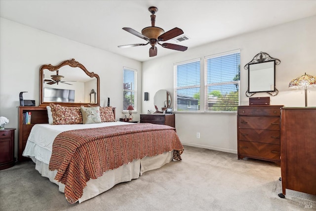 carpeted bedroom with visible vents, a ceiling fan, and baseboards